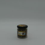 Kawałki naturalnego propolisu w przezroczystym słoiku na białym tle