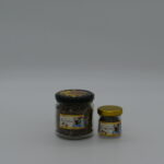 Kawałki naturalnego propolisu w przezroczystym słoiku na białym tle